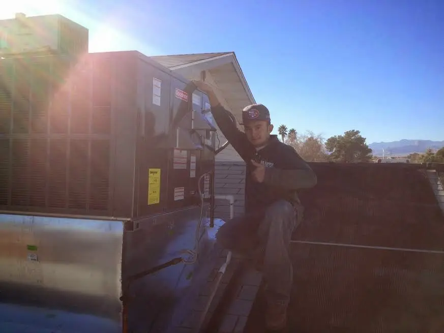HVAC technician performing Heat Pump Repair on a rooftop unit in Germantown